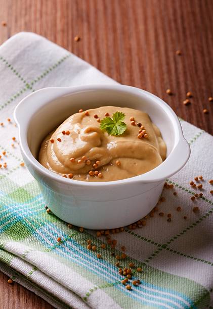 istock White bowl full of mustard on green towel 532172132