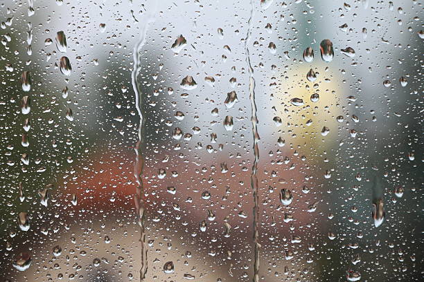 istock Rain drops on window with house and church in background 532172302