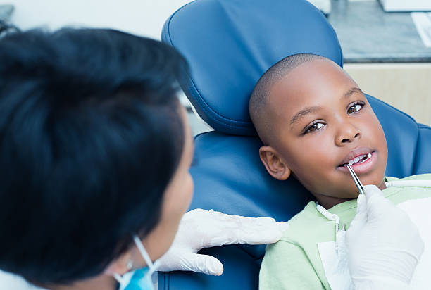 istock Dentist examining boys teeth in the dentists chair 532172477