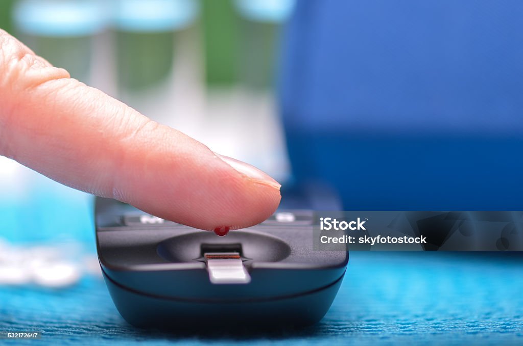 Blood glucose meter Blood glucose meter and finger 2015 Stock Photo