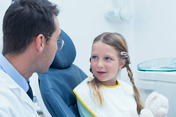 istock Male dentist examining girls teeth 532172903