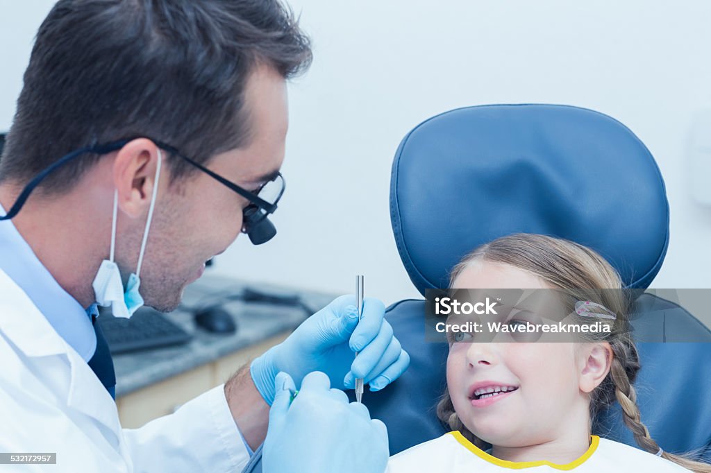 Male dentist examining girls teeth Male dentist examining girls teeth in the dentists chair 16-17 Years Stock Photo