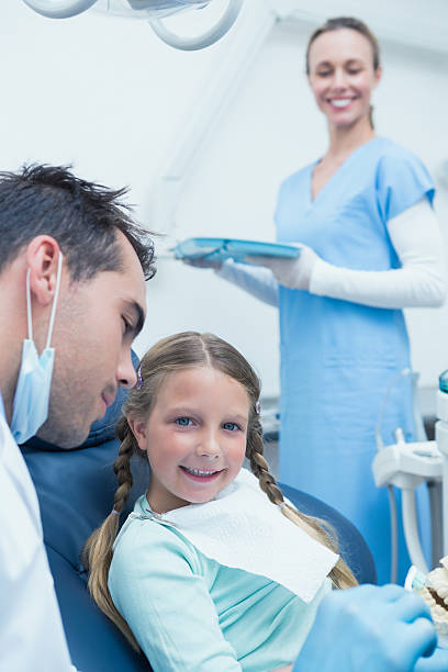 istock Male dentist teaching girl how to brush teeth 532173921