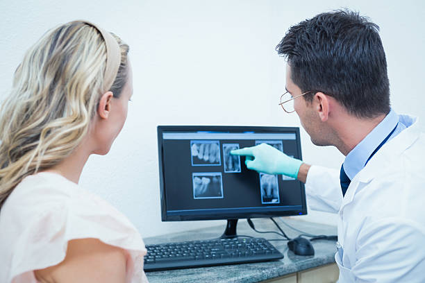 istock Dentist showing woman her mouth x-ray on computer 532173935