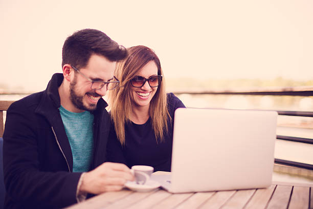 istock Couple sitting at cafe and looking at laptop 532174204