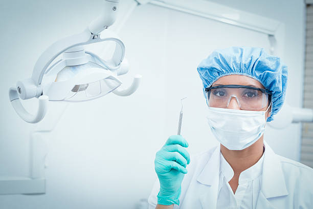 istock Dentist in surgical mask and safety glasses holding hook 532174505
