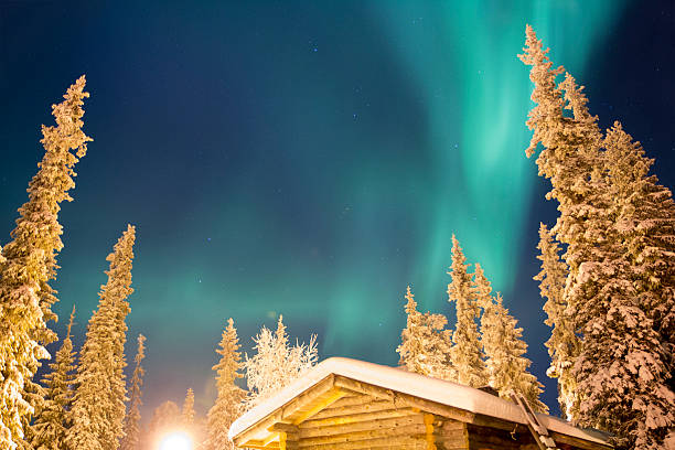 Northern light (aurora borealis) above a cabin, Lapland Finland stock photo