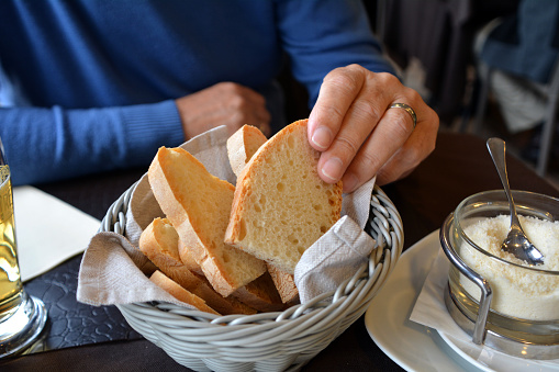 Man has on a hand fresh italian bread ciabatta on a restaurant