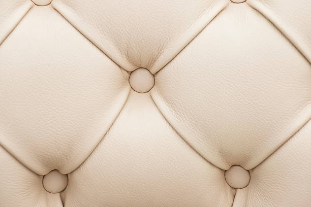 Detail of a beige leather back rest with buttons.