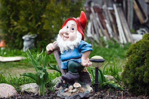 Statue of little gnome staying at a private garden in Riga.