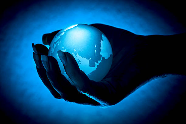 istock blue Earth glas ball in Hand against blue / black 532184551