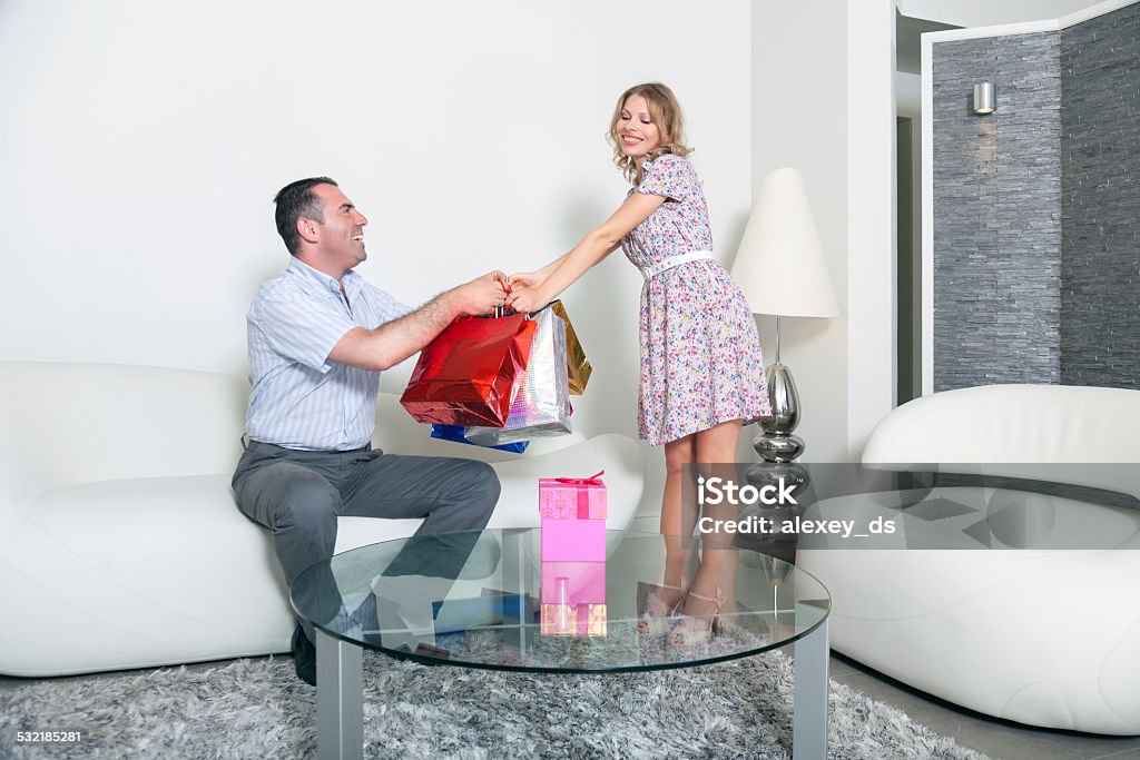 Husband gives packages with gifts to pleased wife 2015 Stock Photo