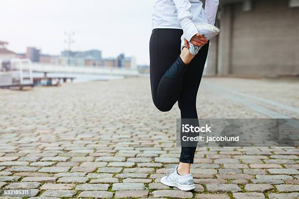 Fit Young Woman Stretching Her Leg Before A Run Stock Photo - Download Image Now - Calf - Human Leg, Stretching, 2015