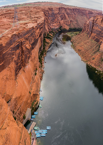 United States. Arizona. Coconino County. Colorado River close to the Glen Canyon Dam on Lake Powell. Lake Powell is a reservoir on the Colorado River, between Utah and Arizona. It is a vacation spot visited by two million people every year. It lies on an area of 161,390 acres (65,310 ha) and has 1960 miles (3161 km) of shoreline (more than the entire Pacific coast of USA). Because of its ecological effect on the Colorado River and on the environment, Lake Powell and its dam have inspired heavy controversy from environmentalists.