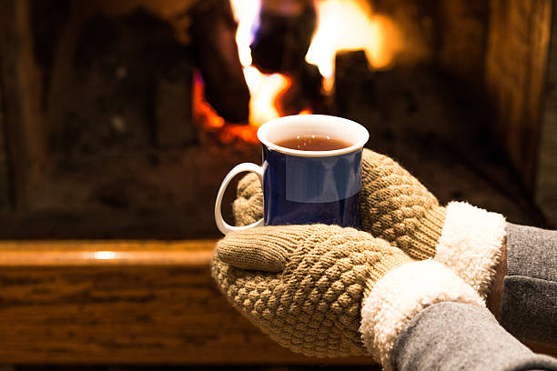 istock Hot tea in hands and fireplace background 532185723