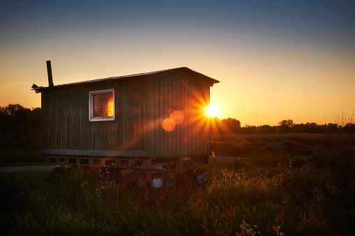 Old caravan on field countryside sunset