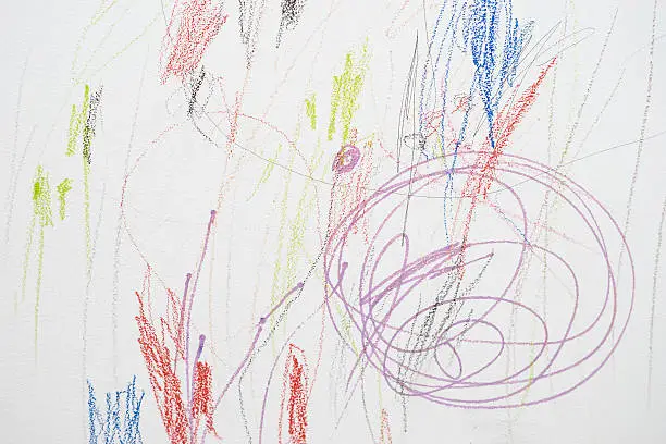 Colored pencils scribbles on a white wall made by a little kid that could pass as abstract work.