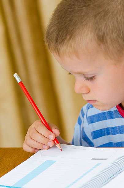 istock Beautiful child writing with a red pen 532187399