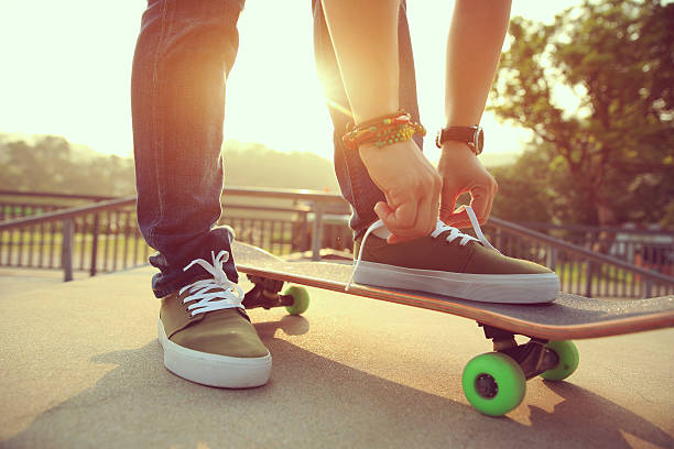 istock skateboarder tying shoelace at skatepark ramp 532188522
