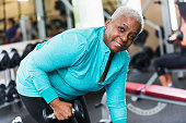 Senior African American woman at gym lifting weights
