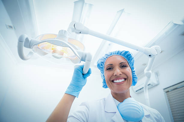 istock Smiling female dentist adjusting light 532189515