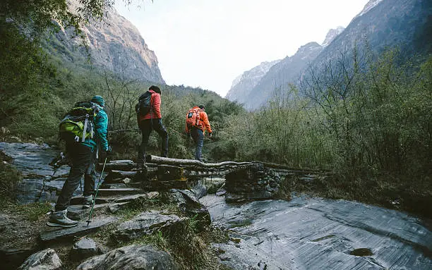 Group of trekkers cross the bridge at Annapurna region on Himalayas.
