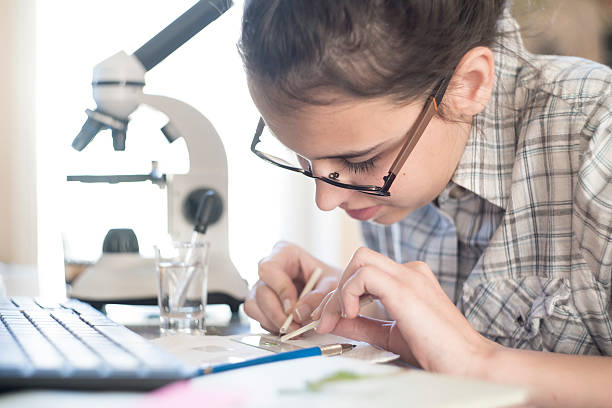 istock Teenage girl make homework scientific project with microscope 532191154