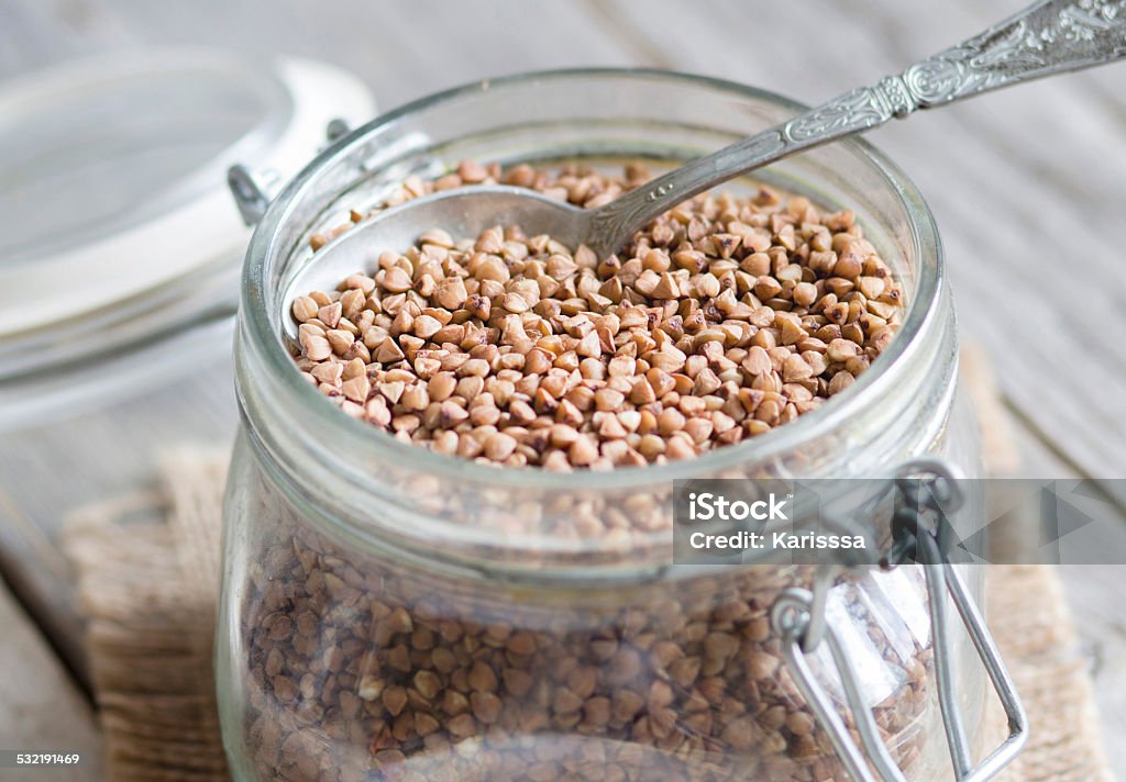 Buckwheat in a glass jar Buckwheat in a glass jar with a spoon 2015 Stock Photo