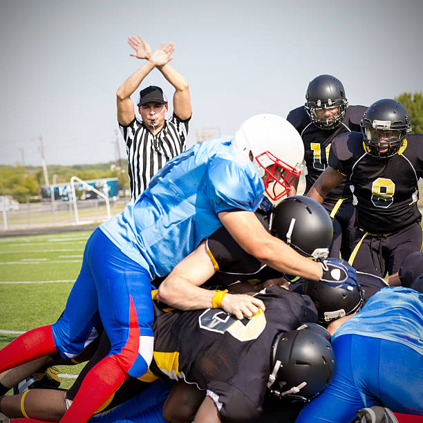 istock Referee blowing whistle after tackle on football field 532192189