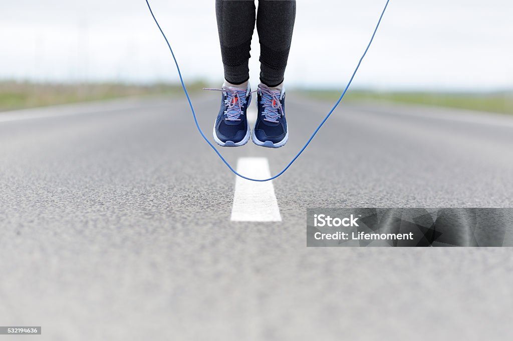 Woman doing jump roping on a sports field. Woman doing jump roping on a sports field 30-34 Years Stock Photo