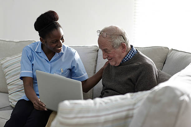 istock Active senior man using laptop with female carer at home 532203393