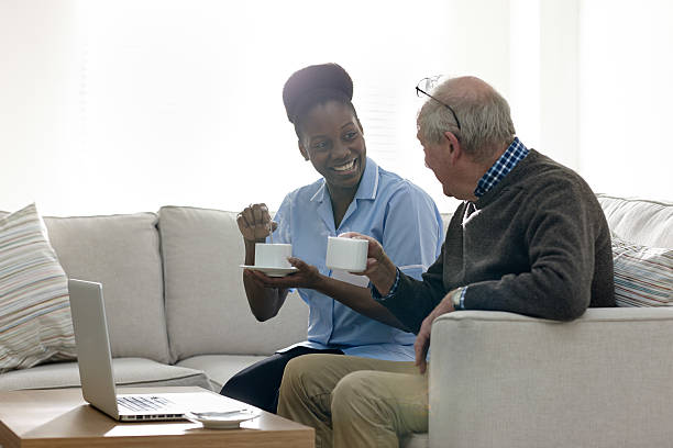 istock Relaxed elderly man and female nurse having coffee 532205321