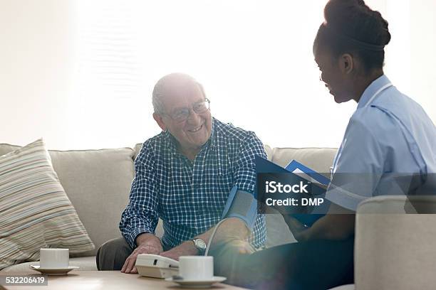 Retired Senior Man Having Health Check With Nurse At Home Stock Photo - Download Image Now