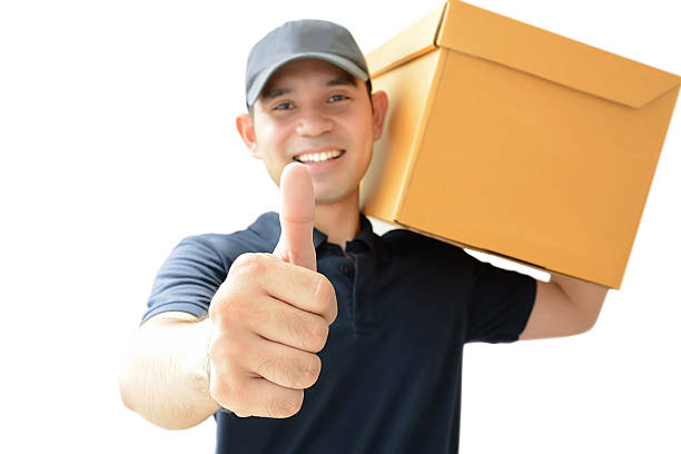 istock Deliveryman carrying a parcel box giving thumbs up 532223557
