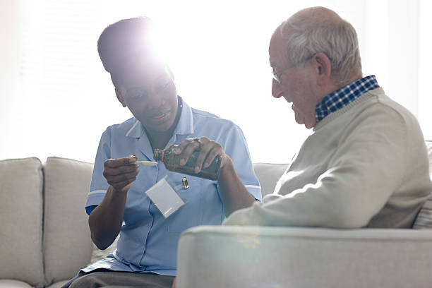 istock Nurse giving syrup to unwell elderly patient 532223959