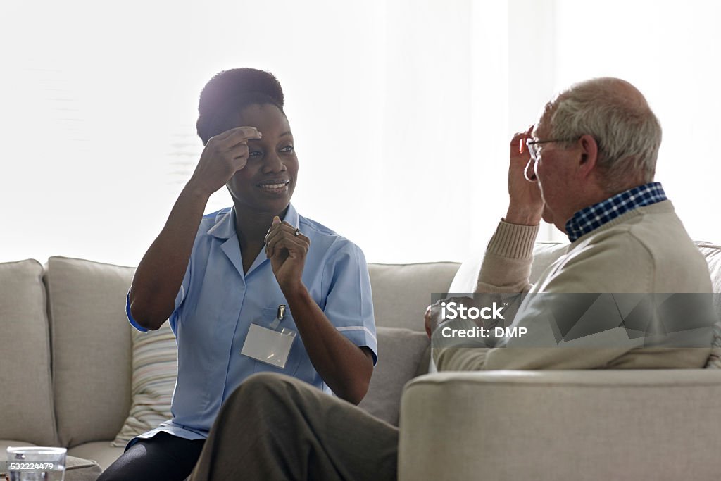 Therapist carrying out EFT treatment with elderly patient Female therapist carrying out EFT treatment with elderly patient at home Sign Language Stock Photo
