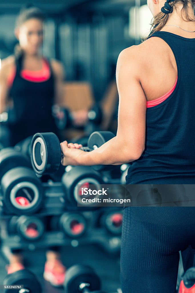 Woman in health club Woman in health club exercising with weights Gym Stock Photo
