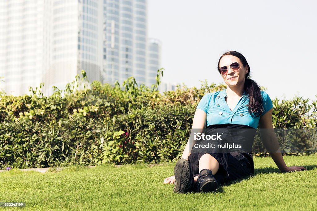 tourist to dubai taking a break a female tourist to dubai taking a break, sitting in the grass. 20-29 Years Stock Photo
