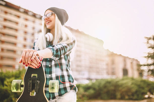 istock Cute blond girl enjoing in sunset with her longboard 532248402