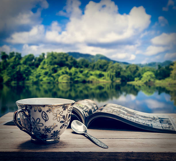 Coffee cup with magazine on wooden table