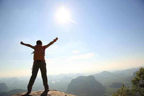istock cheering woman hiker open arms at mountain peak 532259940
