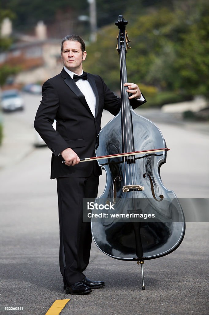 man playing the double bass in the street man in tuxedo playing the double bass in the middle of the street Double Bass Stock Photo