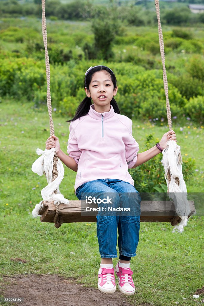 Asian kid swinging Asian kid swinging on the meadow 2015 Stock Photo