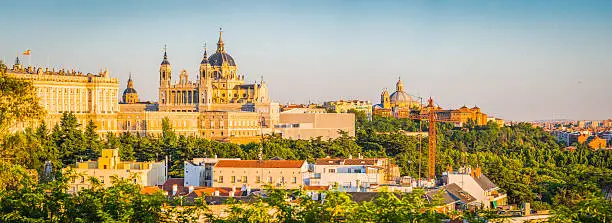 Warm light of late afternoon illuminating the ornate domes and spires of the Almundena Cathedral and classical facade of the Palacio Real across the rooftops of central Madrid, Spain's vibrant capital city. ProPhoto RGB profile for maximum color fidelity and gamut.