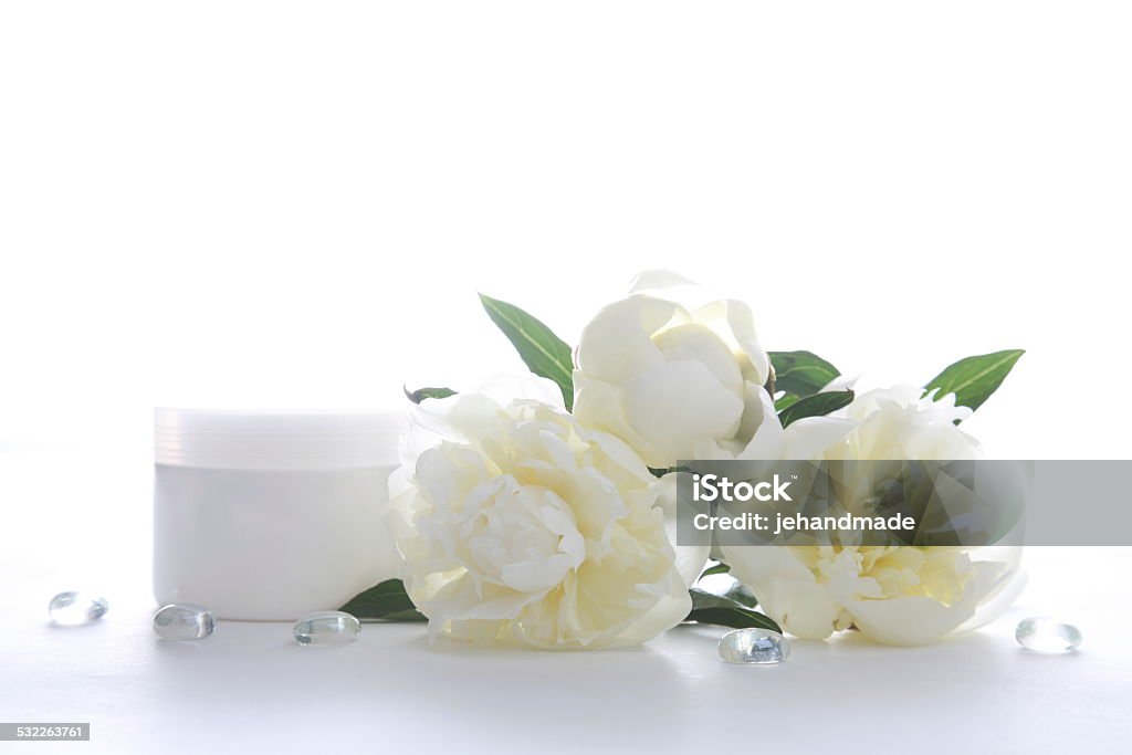 Cosmetic can ore jar in white color with beautiful peony Perfume Stock Photo