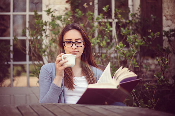 istock Young woman reading a book at the veranda 532268290