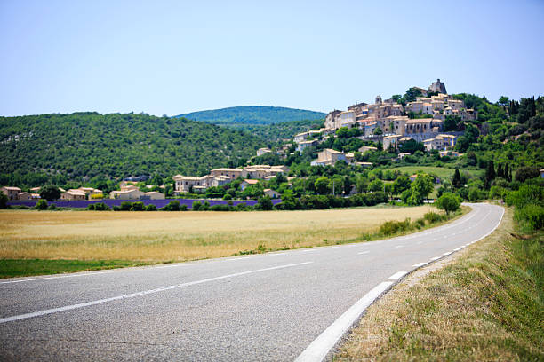 straße zu einer kleinen stadt in der provence - clear sky village landscape landscaped stock-fotos und bilder