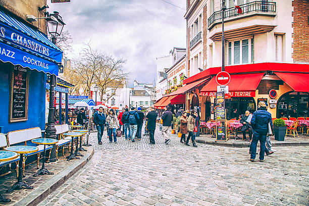 Montmartre, Paris Paris, France - April 26, 2016: Street scene view with tourists and restaurants from Montmartre, Paris, France. Monmartre is very popular among visitors and tourists in Paris. place pigalle stock pictures, royalty-free photos & images