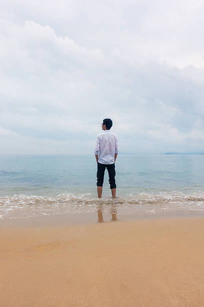 istock Young man standing on the beach 532275550
