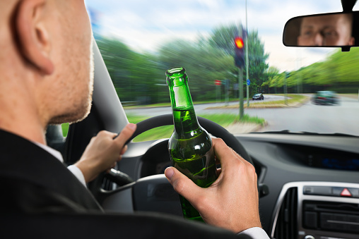 Close-up Of A Businessman Drinking Beer While Driving Car